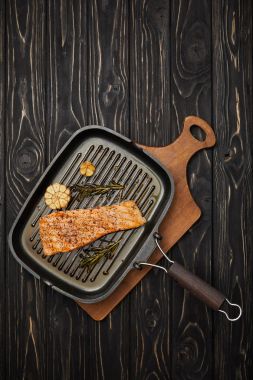siyah ahşap masa üzerinde kesme tahtası üzerinde görücü usulü ızgara somon Steak rosemary ile Üstten Görünüm