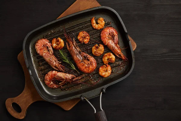 Bovenaanzicht Van Gegrilde Garnalen Met Rozemarijn Houten Snijplank Zwart Tafelblad — Stockfoto