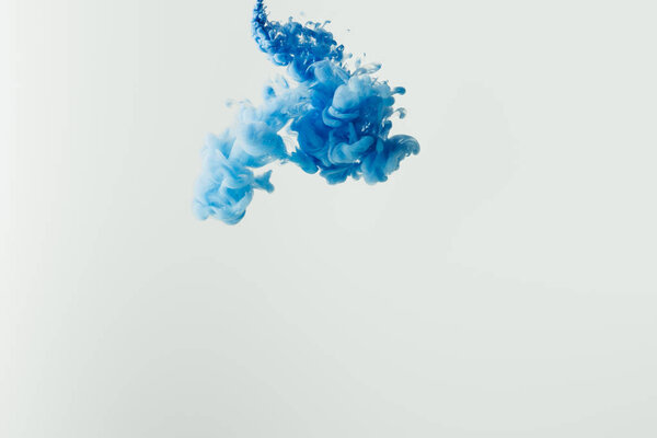 Крупным планом снимок ярко-голубой краски, выплеснувшейся в воду, изолированный от внешнего мира
