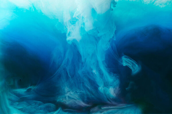 full frame image of mixing of blue, black, turquoise and white paints splashes in water