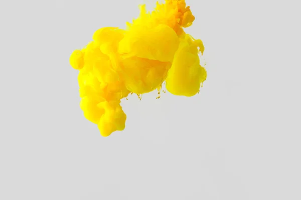 stock image close up view of bright yellow paint splash in water isolated on gray