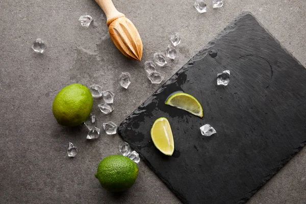 Flat Lay Wooden Squeezer Limes Ice Cubes Cocktail Grey Surface — Stock Photo, Image