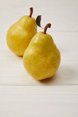 raw organic yellow pears on wooden background clipart