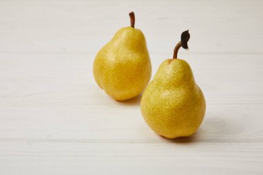 two fresh yellow pears on wooden background clipart