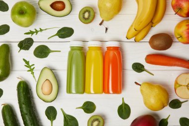 satırda ile meyve ve sebze ahşap arka plan üzerinde Detoks smoothies ile şişe ile düz lay