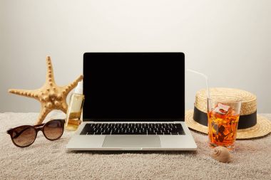 Görünümü boş ekran, kokteyl ve yaz tatil aksesuarları kum gri arka plan üzerinde üzerinde yenileme ile dizüstü kadar kapatın