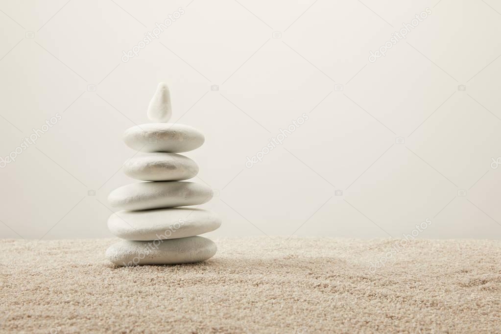 close up view of arranged white sea stones on sand on grey background