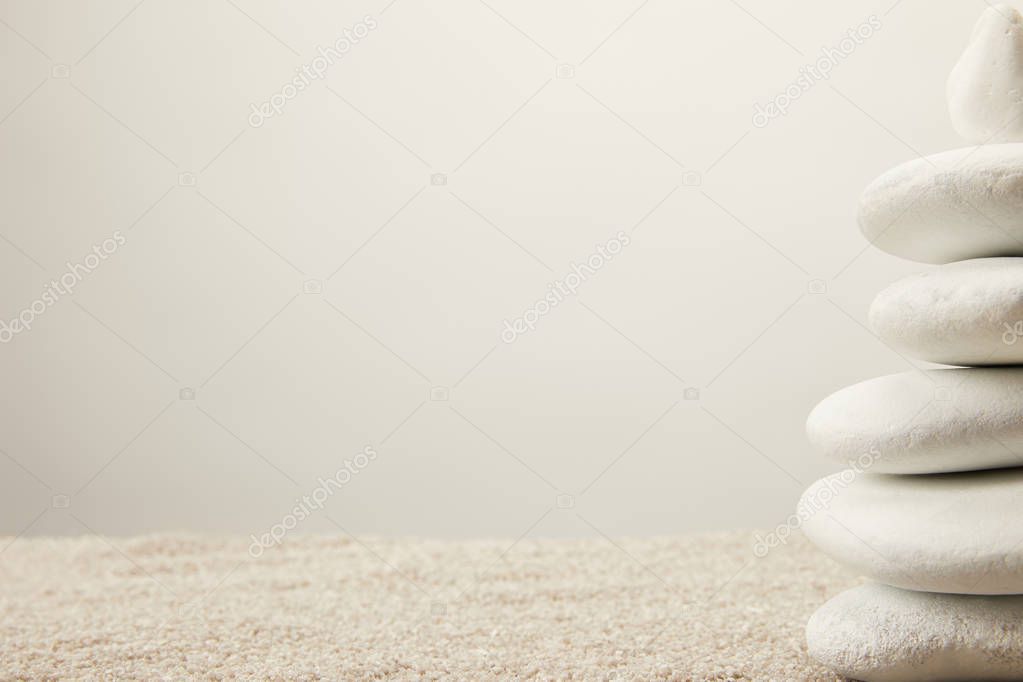 close up view of arranged white sea stones on sand on grey background