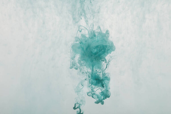abstract design with flowing turquoise paint in water