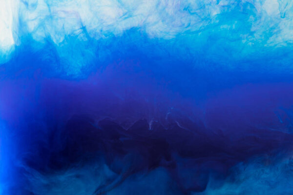 artistic background with flowing blue smoky paint in water