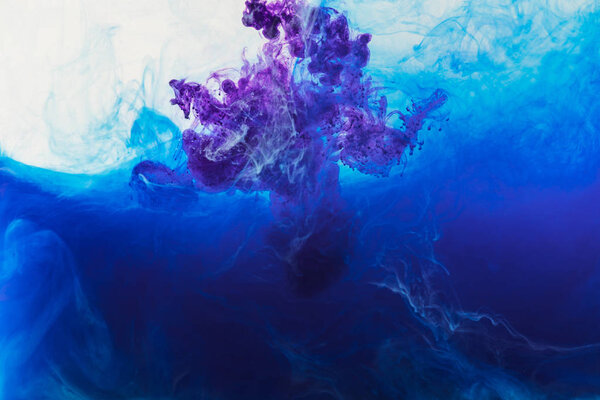 abstract design with flowing blue and purple paint in water