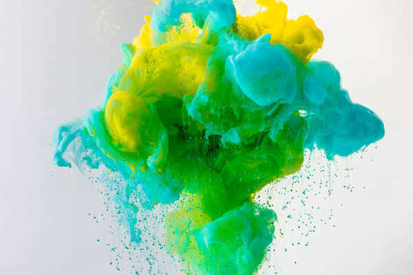 wallpaper with flowing turquoise, yellow and green paint in water, isolated on grey