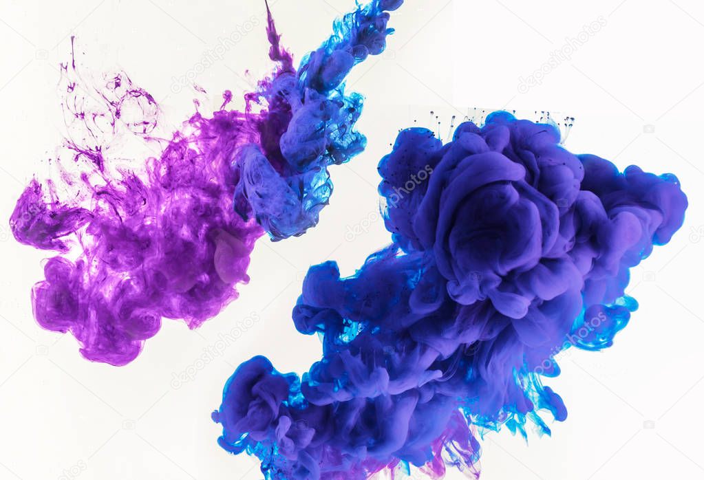 abstract design with smoky splashes of blue and purple paint in water, isolated on white