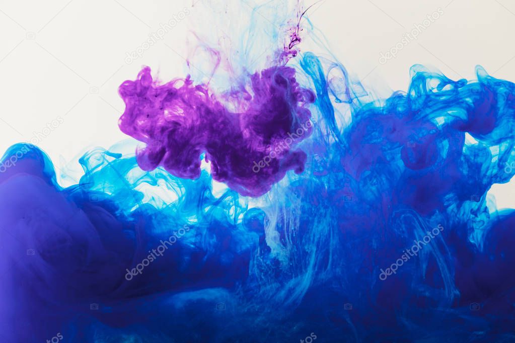 abstract texture with blue and purple paint flowing in water
