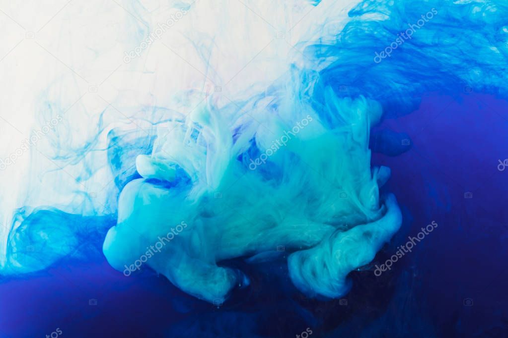 abstract texture with flowing blue and purple paint in water
