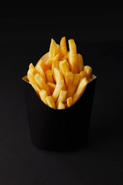 close-up shot of black box of tasty french fries isolated on black isolated on black
