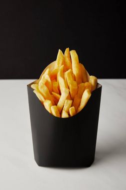 close-up shot of box of french fries on white marble surface isolated on black clipart