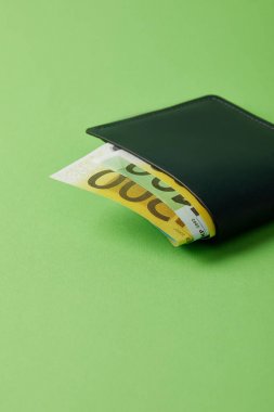 yakın çekim yeşil yüzey üzerinde euro banknot ile cüzdan vurdu