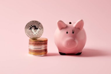 bitcoins ve kumbara pembe üzerinde yığını
