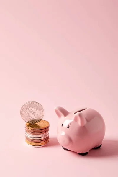 粉红色桌面上的比特币和小猪银行栈 — 图库照片