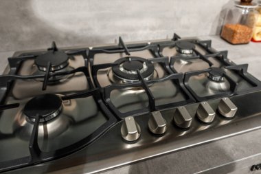 Close-up view of metal stove in renovated kitchen  clipart