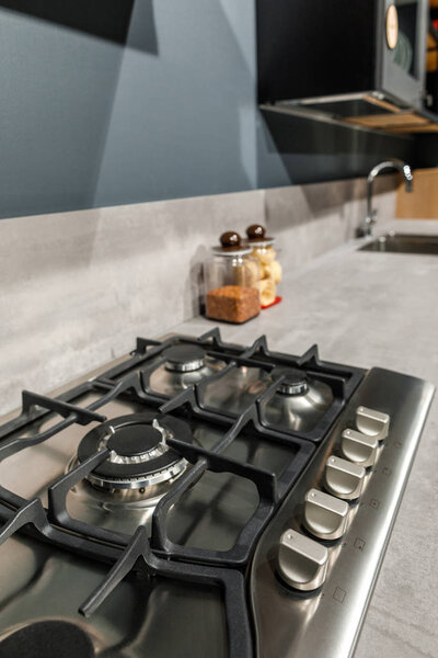 Интерьер современной кухни с металлической плитой на прилавке
