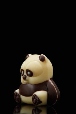 closeup shot of panda shaped chocolate on black background  clipart