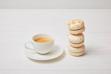 kahve fincanı ve yığın macaroons beyaz tahta masada closeup çekim 