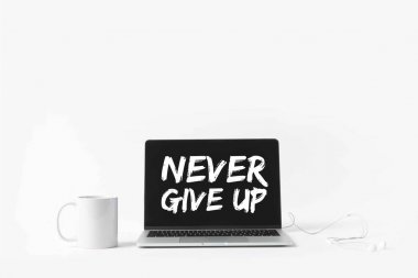laptop with Never give up inspiration on screen, earphones and white mug, isolated on white  clipart