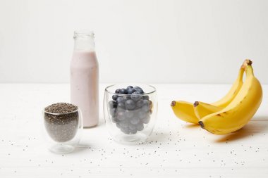 yaban mersini ve muz ile chia puding tatlısı için malzemeler bakış beyaz ahşap yüzey üzerinde kapatın
