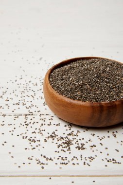 chia tohum ile ahşap kase bakış beyaz yüzey üzerinde kapatın