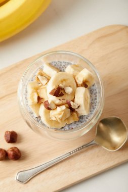lezzetli chia tohum puding muz adet ve fındık ile üstten görünüm üzerinde beyaz masa üstü