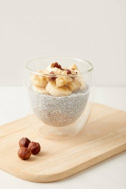 lezzetli chia tohum puding muz ve fındık parçaları ile bakış ahşap kesme tahtası üzerinde kapatın 