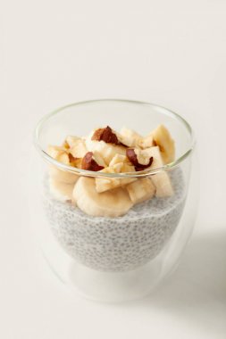 lezzetli chia tohum puding muz ve fındık parçaları ile bakış beyaz masa üzerinde kapatın