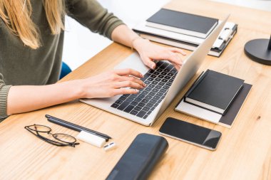 laptop notebook, gözlük ve Office smartphone ile işyerinde yazarak işkadını kısmi görünümünü