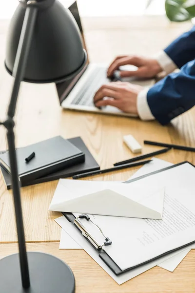 Selectieve aandacht van zakenman bezig met laptop op werkplek op kantoor — Gratis stockfoto