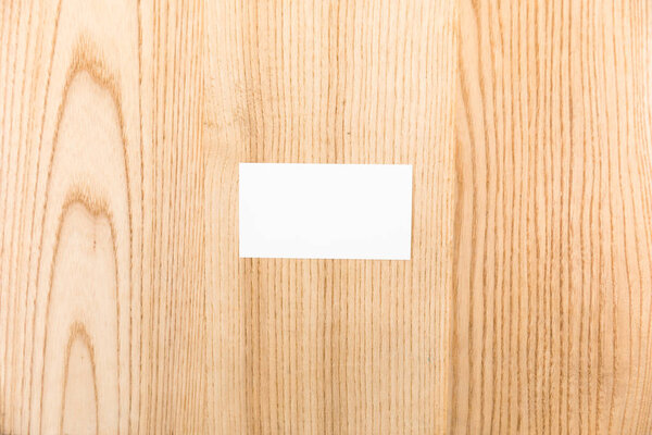 top view of blank card on wooden surface