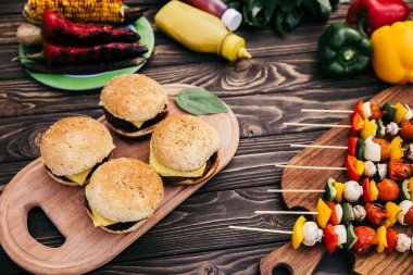 Seasonal vegetables and burgers grilled for outdoors barbecue clipart