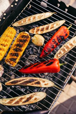 Corn and peppers cooked outdoors on grill clipart
