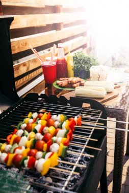 Seasonal vegetables and mushrooms on skewers cooked outdoors on grill clipart
