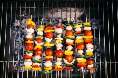 Top view of seasonal vegetables and mushrooms on skewers grilled for outdoors barbecue clipart