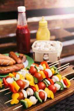 Closeup view of vegetables with mushrooms served outdoors on wooden table clipart