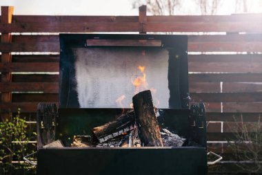 Logs burning in grill for barbecue outdoors clipart