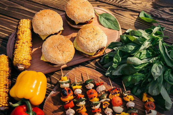Hot delicious burgers and vegetables cooked outdoors on grill