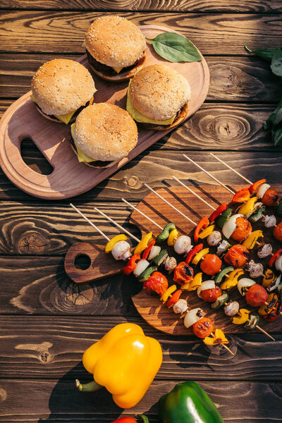 Table with vegetables and burgers grilled for outdoors barbecue