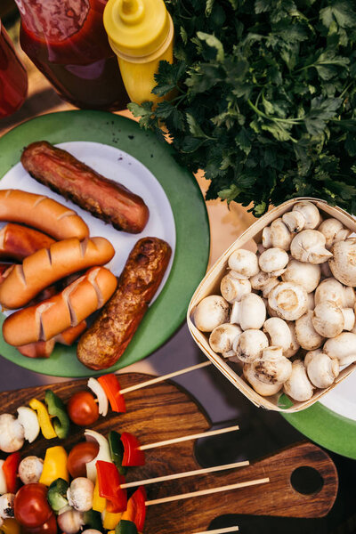 Hot delicious sausages and vegetables with mushrooms cooked outdoors