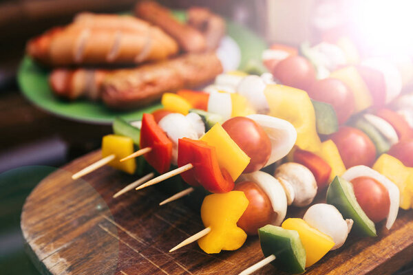 Closeup view of vegetables with mushrooms and sausages grilled for outdoors barbecue