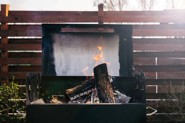 Сжигание бревен в гриле для барбекю на открытом воздухе
