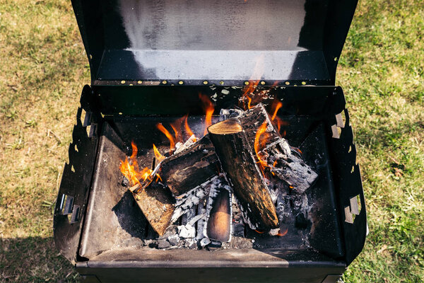 Гриль на открытом воздухе с горящей дровами для барбекю
