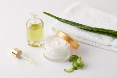 organik dondurma ve parfüm, pipet, havlu ve aloe vera dilimleri ve yaprak beyaz yüzeyi 